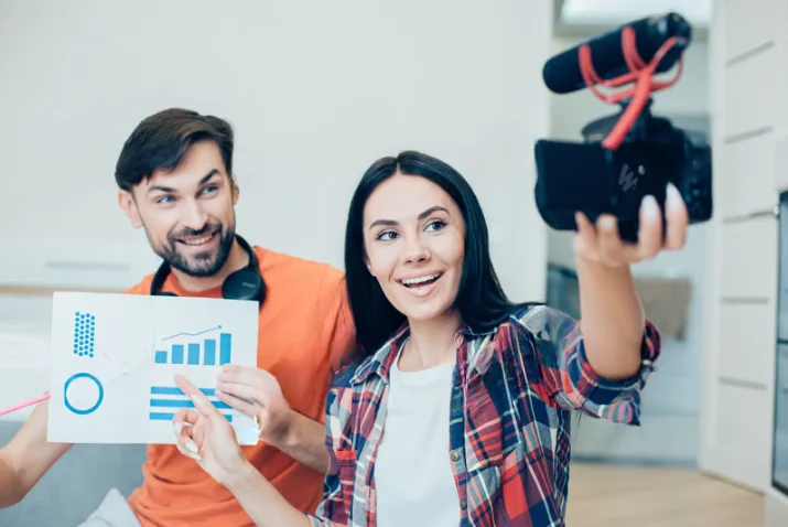 Content creators recording a social media video and reviewing analytics